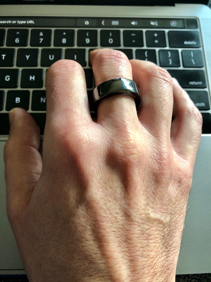 Oura Ring on my hand above Macbook keyboard